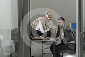 Image of two young businessmen partners looking at business document at meeting office