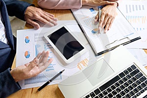 Image of two young businessmen partners looking at business document in touchpad at meeting office