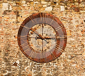An image of a very old clock on a brick wall
