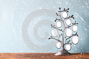 Image of vintage antique classical frame of family tree on wooden table and glitter lights background . filtered image.