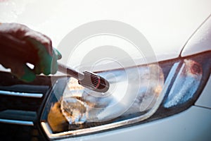 Washing a car`s lamp with pressurized water photo