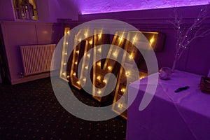 Image of a wedding reception room with large illuminated letters spelling out the word "love"