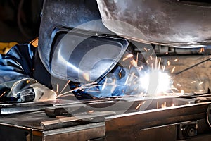 image of the welder with safety helmet and mask at work.