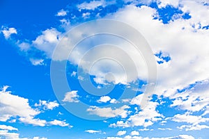 An image of white clouds in a bright, blue sky