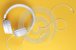 Image of white headphone on yellow background. Music concept.