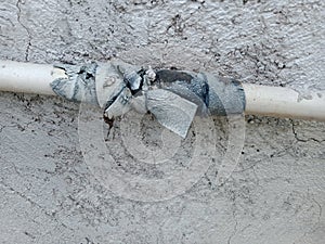 image of a white PVC water pipe tied with a black rubbe