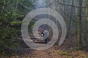 Image of a woman asking if she can follow a path that is obstructed by fallen tree trunks