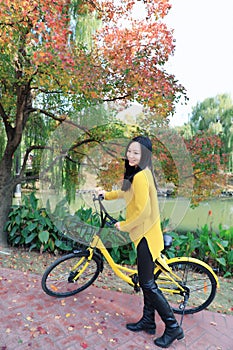 Image of woman with bicycle in a park