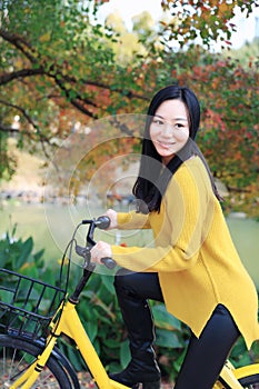 Image of woman with bicycle in a park