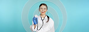 Image of woman doctor, listening patient lungs with stethoscope, doing medical checkup in clinic, standing over blue