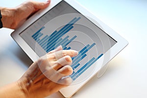 Image of woman hand pointing at touchscreen with business graph