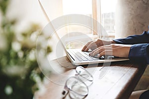 Image of woman hands using / typing on laptop computer selected focus on keyboard