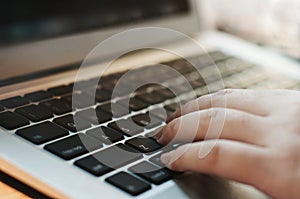 Image of woman hands using / typing on laptop computer selected focus on keyboard