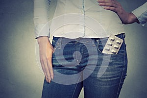 Image of a woman with pills in her pocket