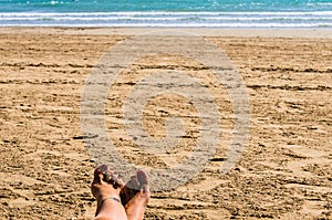 Woman feet in the sand with red painted nails