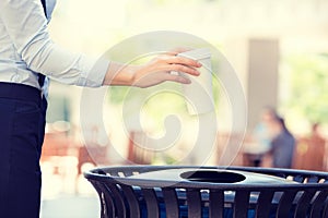 Image woman's hand throwing empty coffee cup in recycling bin