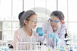 Image of woman teacher and girl student in lab science class. Young girl excited in lab class with scientist