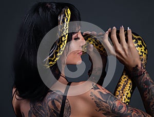 Image of the woman with yellow anaconda on shoulders and head