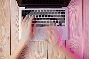 Image of womanâ€™s hands typing fast on laptop keyboard. View from above. Remote work concept image