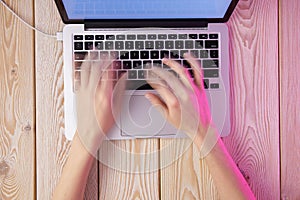 Image of womanâ€™s hands typing fast on laptop keyboard. View from above. Remote work concept image