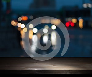 Image of a wooden bar by a window in a pub in front of the blurred lights of a night city