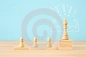 Image of wooden chess ponds over table, building a strong team, human resources and management concept.