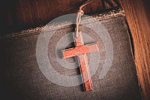 Image of wooden cross on bible background