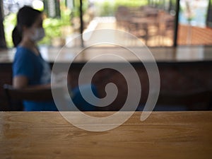 Image of wooden table in front of abstract Blurred background : Customers are waiting  in a coffee shop blur background with bokeh