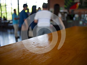 Image of wooden table in front of abstract Blurred background : Customers are waiting  in a coffee shop blur background with bokeh