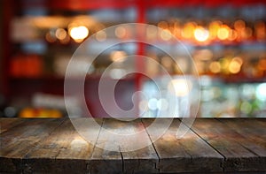 Image of wooden table in front of abstract blurred background of restaurant lights