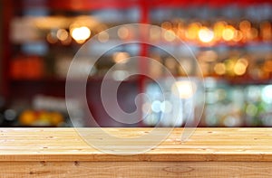 Image of wooden table in front of abstract blurred background of restaurant lights