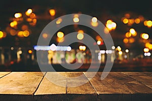 Image of wooden table in front of abstract blurred restaurant lights background