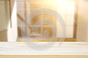 image of wooden table in front of abstract blurred window light background.