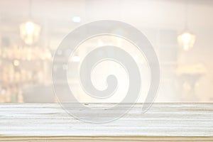 Image of wooden table in front of abstract blurred window light background