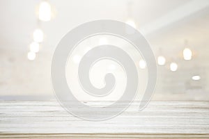 Image of wooden table in front of abstract blurred window light background