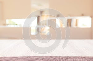 image of wooden table in front of abstract blurred window light background