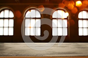 Image of wooden table in front of abstract blurred window light background