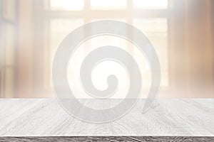 Image of wooden table in front of abstract blurred window light background