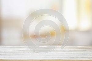 image of wooden table in front of abstract blurred window light background