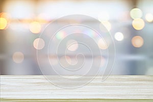 image of wooden table in front of abstract blurred window light background photo