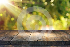 Image of wooden table in front of blurred vineyard landscape at sun light. Ready for product display montage.