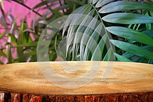 image of wooden table in front tropical green floral background. for product display and presentation