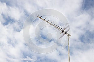 Image of a Yagi-Uda type television antenna with a cloudy sky in the background