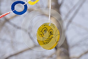 The image is a yellow ball with a smiley face emoticon .On a street background.