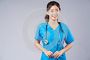 Image of young asian female doctor wearing blue uniform on grey background