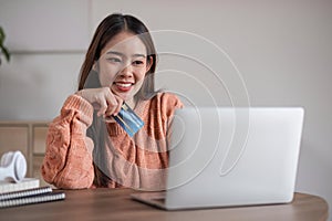 Image of young asian woman order online, shopping from home. Girl enter credit card info on webside to make purchase