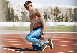 Image of young athlete man preparing for running on racetrack at stadium. Sportsman, male runner sprinting during training session