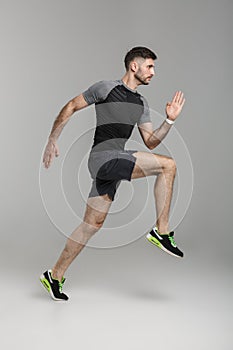 Image of young athletic man in sportswear running while working out