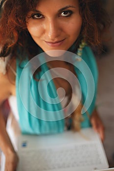 Image of young beautiful joyful woman smiling while working with laptop.