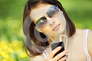 Image of young beautiful woman in summer park reading a message